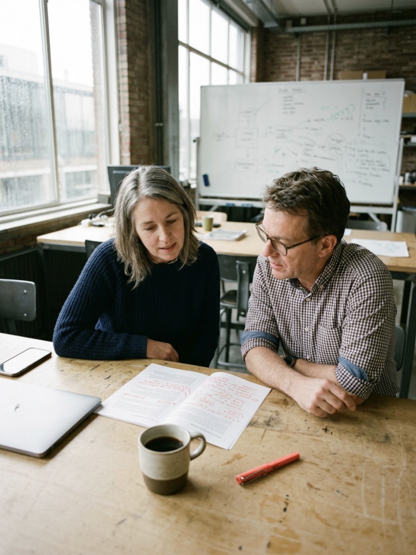 Twee mensen bespreken een overzicht op papier